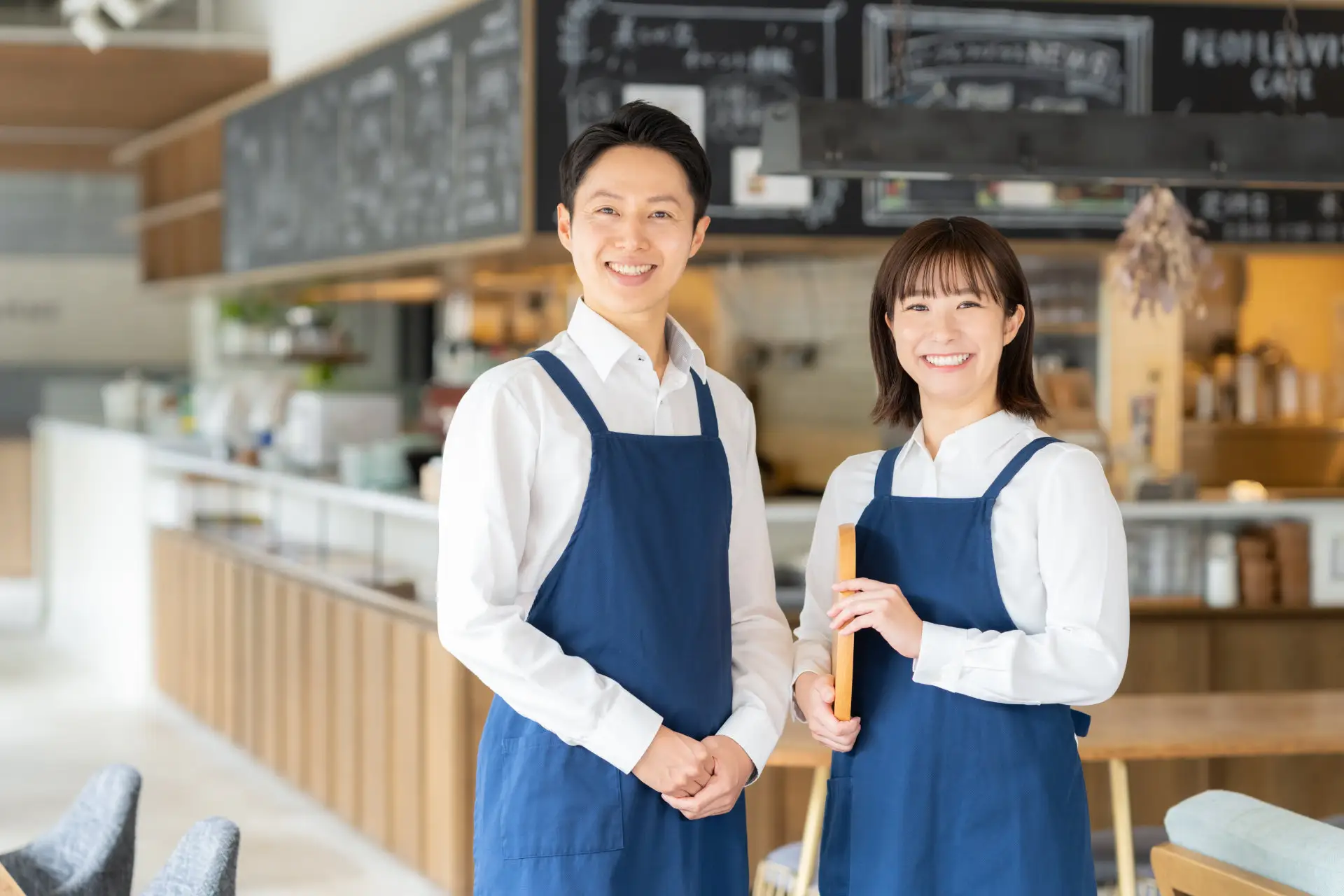 カフェの店内で笑顔を見せるスタッフ二人